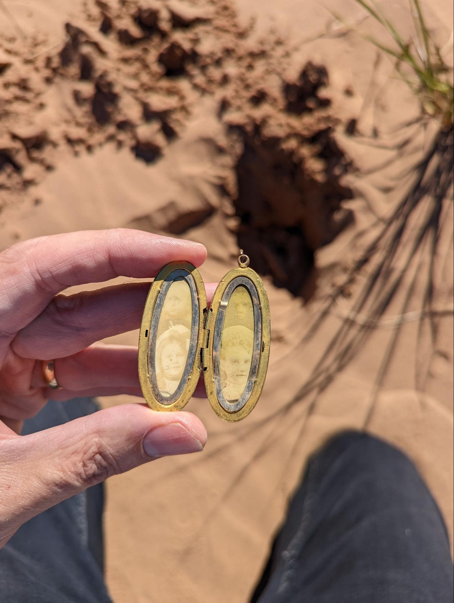 The recovered heirloom locket, opened to show two old family photos